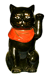Maneki Neko soulève sa patte gauche.
